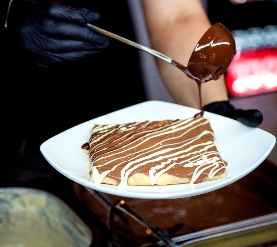 Serwowanie świeżo wypieczonych gofrów w food trucku