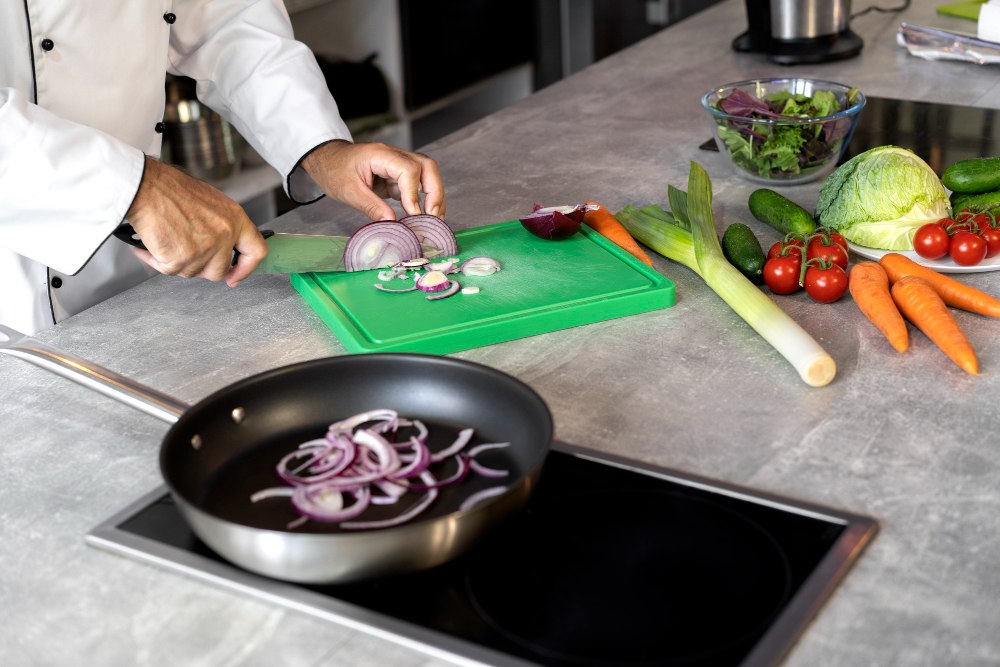 Krojenie cebuli na zielonej desce HACCP – warzywa w gastronomii