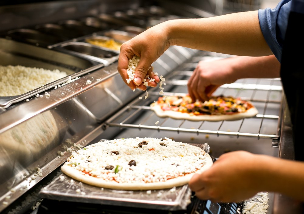 Ergonomia - zorganizowane stanowisko do przygotowywania pizzy z dostępem do składników i urządzeń