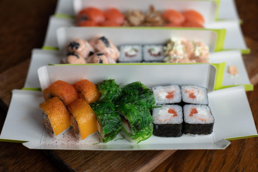 Zestaw sushi w zamykanym opakowaniu z pałeczkami, sosem i logiem lokalu – gotowy do odbioru lub dostawy