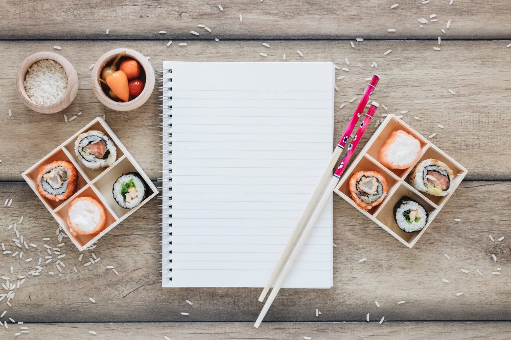Zbliżenie na blat z przygotowanymi składnikami do sushi i checklistą z punktami planu otwarcia