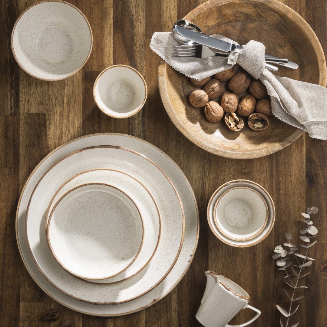 Piaskowa porcelana w naturalnej aranżacji świątecznego stołu z gałązkami i orzechami