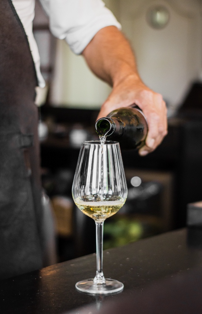 Profesjonalna obsługa kelnerska nalewająca wino do kieliszków gastronomicznych podczas eventu