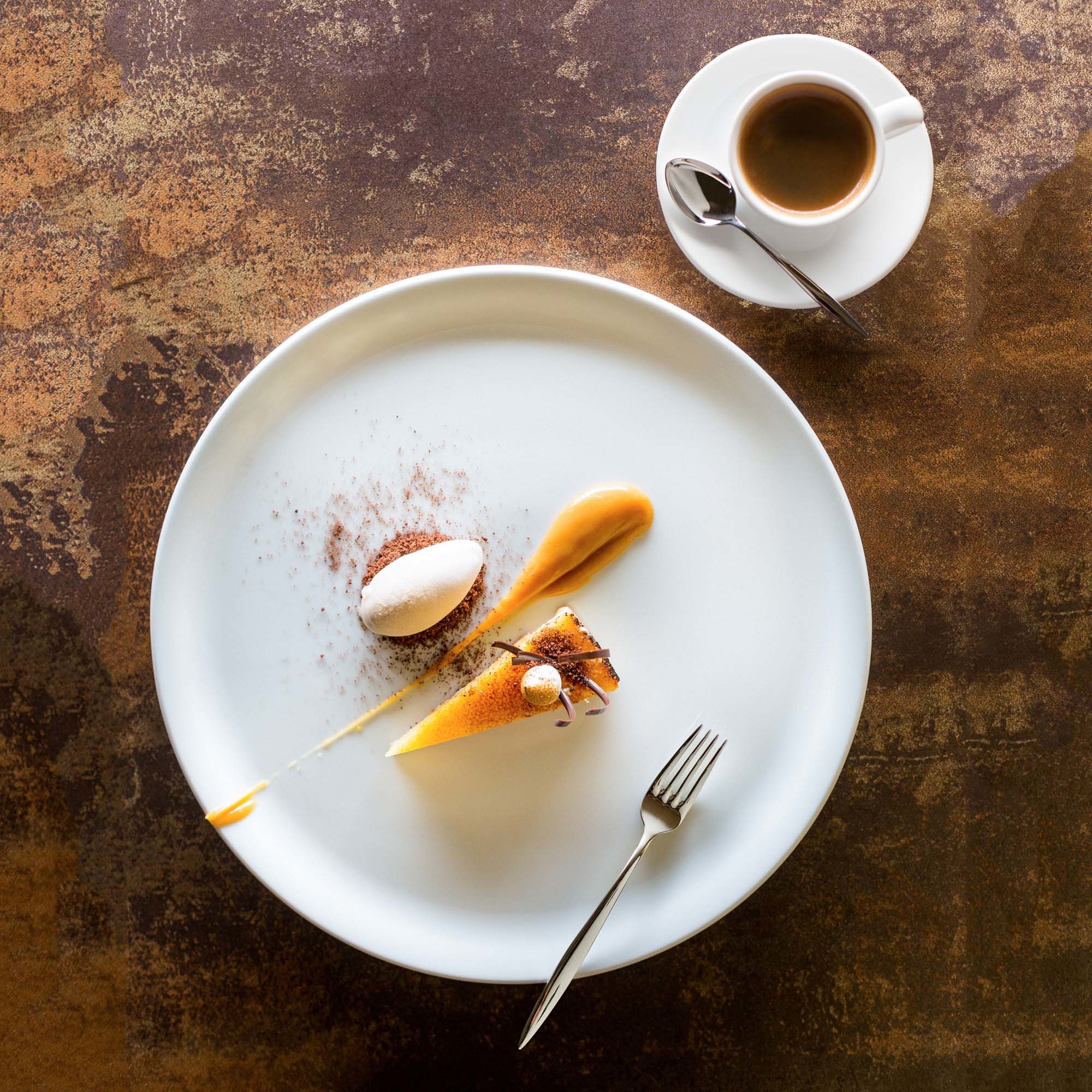 Śnieżnobiały talerz płaski Fine Dine Bianco na tle eleganckiego stołu – porcelana do restauracji i cateringu